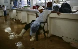 Un vendeur de poisson regarde son téléphone en attendant les clients au marché de fruits de mer de Panama, le 24 septembre 2026
