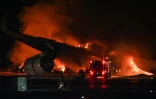L'avion de ligne de la Japan Airlines en feu sur le tarmac de l'aéroport Tokyo-Haneda le 2 janvier 2024 après la collision de l'appareil avec un avion des garde-côtes japonais