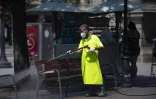 Un employé municipal nettoie un banc sur la Place de Catalogne, dans le centre de Barcelone, le 18 juillet 2020