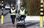 Des volontaires se promènent avec Claire dans sa poussette, une poupée équipée de capteurs pour mesurer la pollution de l'air, à Anvers (Belgique) le 25 janvier 2021.