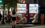 Des femmes se procurent des boissons auprès de distributeurs automatiques, le 13 avril 2026 à Tokyo

