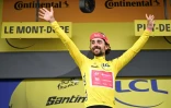 L'Irlandais Ben Healy sur le podium avec le maillot jaune, au Mont-Dore, le 14 juillet 2025