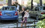 Une femme prend une photo avec son portable d'un bâtiment détruit après avoir été touchée par une frappe de missile dans la ville ukrainienne de Serhiivka, près d'Odessa, tuant au moins 18 personnes et en blessant 30, le 1er juillet 2022