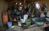Des réfugiés afghans servent de la nourriture à d'autres réfugiés dans un camp près d'Islamabad, le 19 janvier 2018