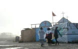 Des migrantes se dirigent vers une église de fortune au campement la "Jungle", le 23 octobre 2016 à Calais