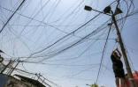 L'Irakien Aqeel Hassan, 42 ans, l'un des propriétaires de générateurs électriques privés, le 17 juillet 2021 en train de réparer des câbles dans son entreprise du quartier de Sadr City à Bagdad, qui alimente 270 foyers en cas de panne du réseau national défaillant