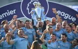 Manchester City et son entraîneur Pep Guardiola soulevant le trophée de Premier League, à Brighton le 12 mai 2019