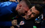Alors que l'avant croate Mario Mandzukic (D) et ses camarades lui tombent dessus dans leur célébration du but de la victoire, le 11 juillet 2018, le photographe de l'AFP Yuri Cortez continue à prendre des photos, en gros plan