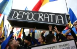 Des manifestants portent un cercueil flanqué de l'inscription "Démocratie" pour dénoncer l'annulation de la présidentielle, le 10 janvier 2025 à Bucarest