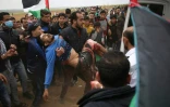 Un jeune Palestinien est porté dans une ambulance après avoir été blessé lors d'affrontements avec les forces israéliennes près de la barrière qui sépare la bande de Gaza et Israël, le 30 mars 2018
