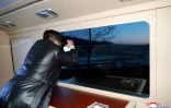 Photo prise le 11 janvier 2022 par l'agence nord-coréenne KCNA montrant ce qui est présenté comme le leader nord-coréen Kim Jong Un regardant avec des jumelles le lancement d'un missile hypersonique, depuis un lieu inconnu en Corée du Nord
