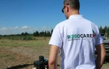 Un technicien de la startup RoboCare se prépare à faire voler un drone au-dessus d'un domaine agricole pour scanner les arbres et évaluer leur niveau d'hydratation ou la qualité du sol, le 30 août 2023 à Nabeul, au Maroc