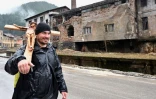 Josip Jelinic, une croix de 8 kilos sur l'épaule, marche le long d'une route pendant son pèlerinage de 1000 km demandant le pardon et la réconciliation de tous les peuples en Bosnie-Herzégovine, près de la ville de Vares, le 25 mars 2025