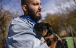 Un chiot dans les bras d'un employé du refuge de Gracanica, le 12 novembre 2021 au Kosovo