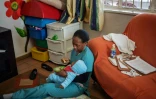 Une nurse nourrit un bébé abandonné à l'orphelinat Door of Hope, le 27 juin 2019 à Johannesburg, en Afrique du Sud