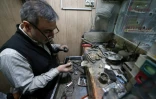 Un fabricant de bagues façonne une bague de pierres précieuses dans une boutique d'un bazar au sud de Téhéran, le 8 janvier 2024