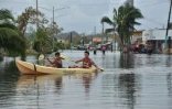 Des habitants utilisent un kayak pour se déplacer dans leur rue inondée, à Juana Matos, sur lîle de Porto Rico, le 21 septembre 2017 après le passage de l'ouragan Maria