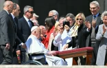 Des fidèles applaudissent le pape François, en fauteuil roulant, après avoir dirigé la prière de l'Angélus, place Saint-Pierre au Vatican, le 6 avril 2025