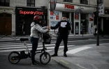Un policier contrôle l'attestation de déplacement d'une cycliste à Paris, le 19 mars 2020