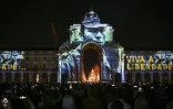 Des photos de la Révolution des Oeillets du photojournaliste portugais Alfredo Cunha projetées sur la façade de l'arc de triomphe de la Rua Augusta, Praca do Comercio, à Lisbonne, le 24 avril 2024
