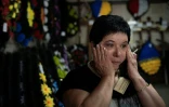 Svitlana Ostapenko, gérante du funérarium de Sumy, dans le nord-est de l'Ukraine, essuie une larme le 10 juin 2025