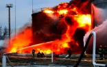 Des pompiers luttent contre un incendie dans un dépôt de carburant touché par des frappes russes, le 26 mars 2022 en Ukraine