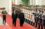 Le leader nord-coréen Kim Jong Un (d) et le président chinois Xi Jinping passent en revue la garde d'honneur, le 19 juin 2018 au Palais du Peuple, à Pékin