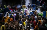 Des migrants attendent devant le centre d'accueil de Lampedusa, le 14 septembre 2023 en Italie