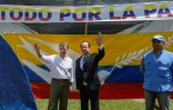 Les présidents colombien, Juan Manuel Santos, et français, François Hollande, sous une bannière "tout pour la paix" lors d'une visite dans un camp de désarmement des Farc, le 24 janvier 2017 à Caldono en Colombie 