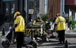 Des livreurs de la plateforme Meituan se reposent entre deux livraisons, à Pékin, le 19 octobre 2021
