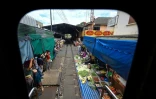 Le marché de Maeklong vu par la fenêtre d'un train de passager, dans la province de Samut Songkhram, le 4 juin 2022 en Thaïlande