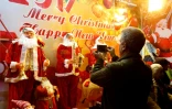 Un Iranien photographie des pères Noël dans la vitrine d'une boutique de Téhéran, le 24 décembre 2016