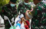 Des médecins militaires soignent une femme blessée dans un camp à Palu, le 4 octobre 2018 en Indonésie