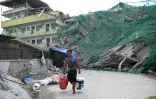 Un habitant transporte des effets personnels récupérés au pied d'un bâtiment effondré à Angeles City, dans la province de Pampanga, au nord de Manille, le 25 mai 2026 aux Philippines