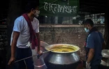 Des volontaires de l'association Mehmankhana préparent un repas pour les personnes affectées par la crise du coronavirus, le 26 juillet 2021 à Dacca