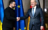 Le chancelier allemand Olaf Scholz (D) serre la main du président ukrainien Volodymyr Zelensky (G) lors d'une réunion bilatérale en marge de la 61e Conférence de Munich sur la sécurité, le 15 février 2025 