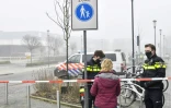 Des policiers bloquent une passante après une explosion qui s'est produite près d'un centre de dépistage du Covid-19 sans faire de blessés, le 3 mars 2021 à Bovenkarspel, aux Pays-Bas
