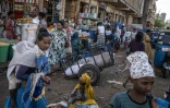 Des acheteurs et des vendeurs transportent des marchandises à l'intérieur du marché Kebele 4 à Bahir Dar, le 9 décembre 2025