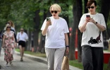 Des femmes utilisent leurs smartphones dans un parc à Moscou, le 30 juillet 2025