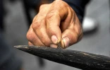 Un manifestant affûte sa lance en bois pendant des négociations entre dirigeants indigènes et le gouvernement, à Quito, le 27 juin 2022