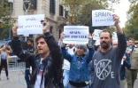 Des mannifestants venus à l'appel du "Tsunami démocratique" en Catalogne brandissent des panneaux "Spain: sit and talk" (Espagne, assieds-toi à la table de discussion), à Barcelone le 21 octobre 2019