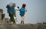 Une fillette, amputée de son bras droit après avoir été blessée pendant la guerre, sort de l'école gérée en partenariat avec l'Unicef dans un camp de personnes déplacées, près de Port-Soudan, le 26 avril 2026 au Soudan