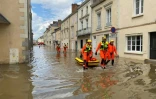 Des secouristes dans une rue inondée de Craon après une crue de l'Oudon, le 20 juin 2024 en Mayenne