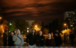 Des habitants observent le site d'une frappe ruasse sur un immeuble résidentiel à Kiev, le 14 octobre 2026 en Ukraine
