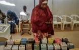 Une femme récupère un bulletin de vote dans un bureau à Dakar, le 24 mars 2024, lors des élections présidentielles