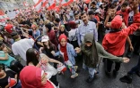 Des manifestants libanais dansent avec des drapeaux nationaux lors d'une manifestation sur la place al-Nour, à Tripoli dans le nord du pays, le 23 octobre 2019