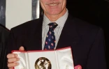 Ted Turner, fondateur de la chaîne américaine d’information en continu CNN, montre son prix d’"Homme de l’année", décerné par le festival de télévision MIPCOM à Cannes, le 14 novembre 1990 dans le sud de la France
