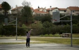 Une femme seule joue au basket-ball, au Holleigh Berson Memorial Park, dans un quartier de Porter Ranch (Californie) où de nombreux habitants ont quitté leur maison après une fuite massive de gaz naturel, dans la vallée de San Fernando, près de Los Angeles, le 22 décembre 2015.