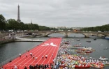 Des athlètes participent à une course sur une péniche, transformée en piste d'athlétisme, le 23 juin 2017 près du pont Alexandre III à Paris, dans le but de promouvoir la candidature de la capitale pour les Jeux olympiques de 2024 
