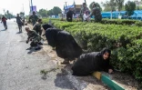 Des femmes et des soldats cherchant à s'abriter lors d'un attentat commis le 22 septembre 2018 pendant un défilé militaire dans la ville iranienne d'Ahvaz